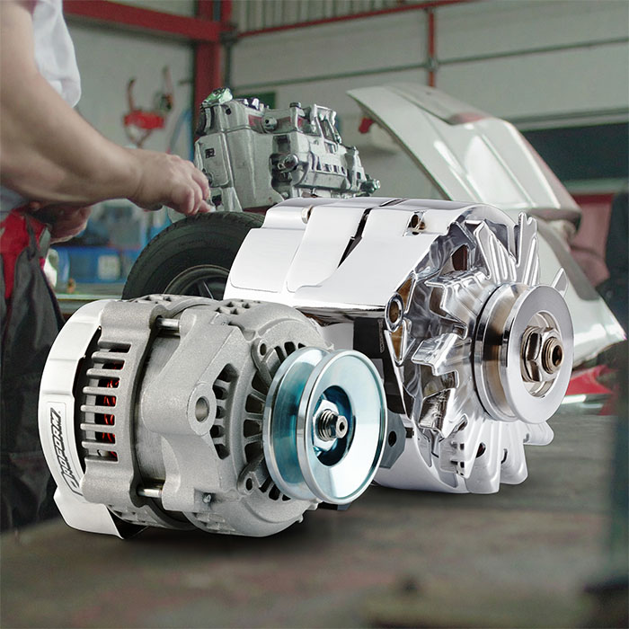 Multiple alternators arranged on a shop bench for comparing amperage options